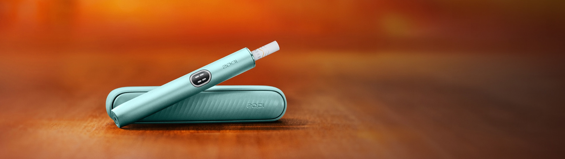 جهاز IQOS ILUMA PRIME باللون الأخضر الزمرّدي وشاحن الجيب.